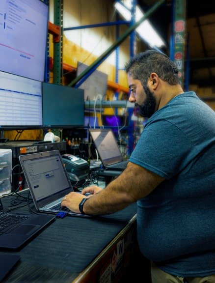 ARCOA employee working on a laptop with many monitors